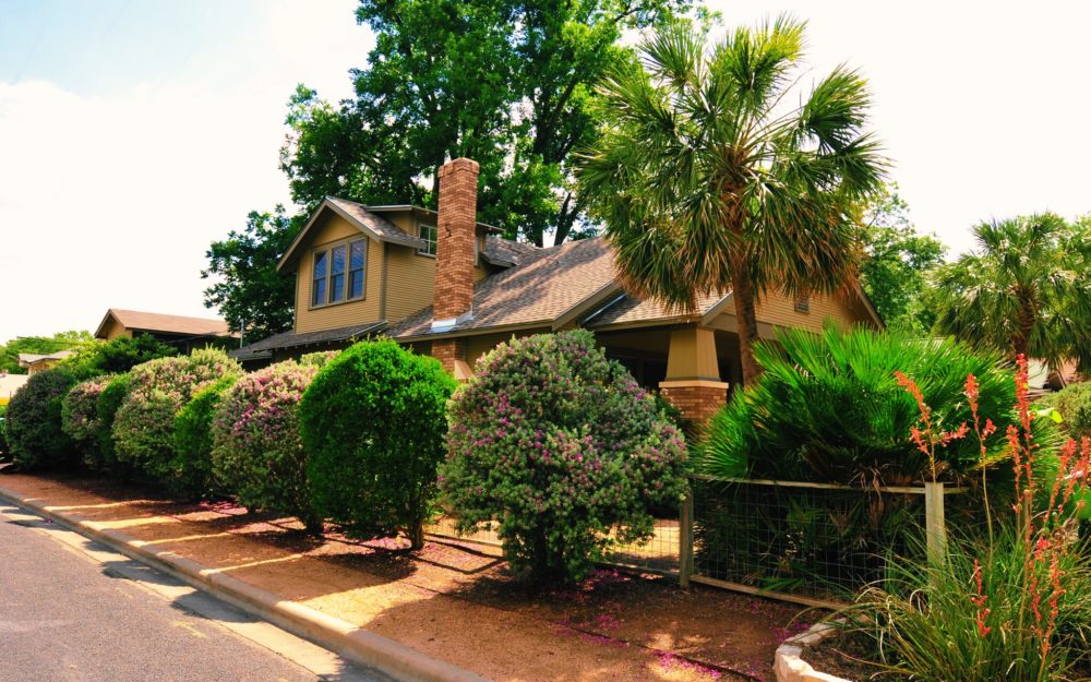 A brown Craftsman style bungalow with a second story addition with shed dormers and a gable roof.